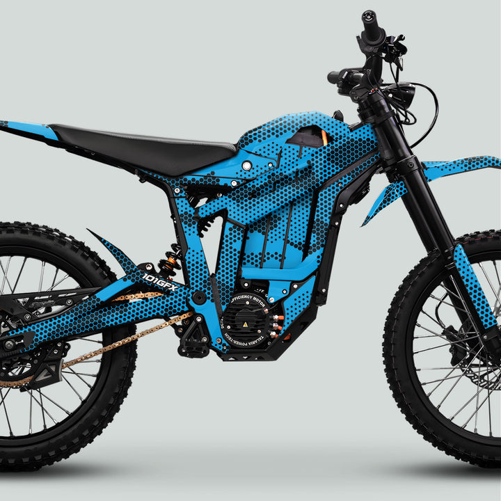 Talaria Sting MX5 PRO Graphics Kit HEXOCAM CYAN Decals on an electric off-road motorcycle, showcasing blue-black honeycomb pattern, knobby tires, and mid-mounted electric motor.