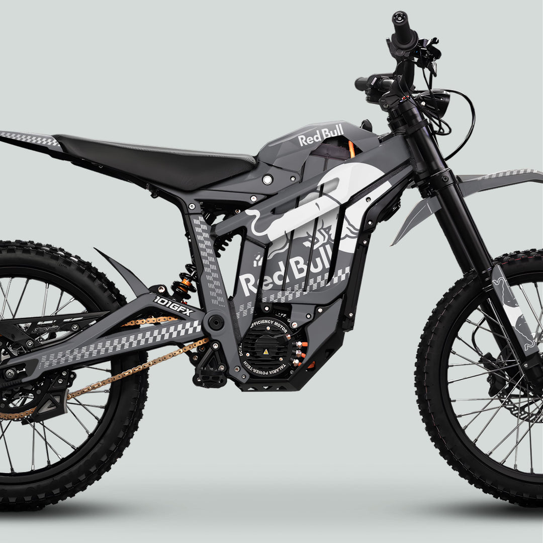 Talaria Sting MX5 PRO Graphics Kit RBULL MONO Grey White Decals on an off-road e-motocross bike with Red Bull branding, chunky tires, and electric components.