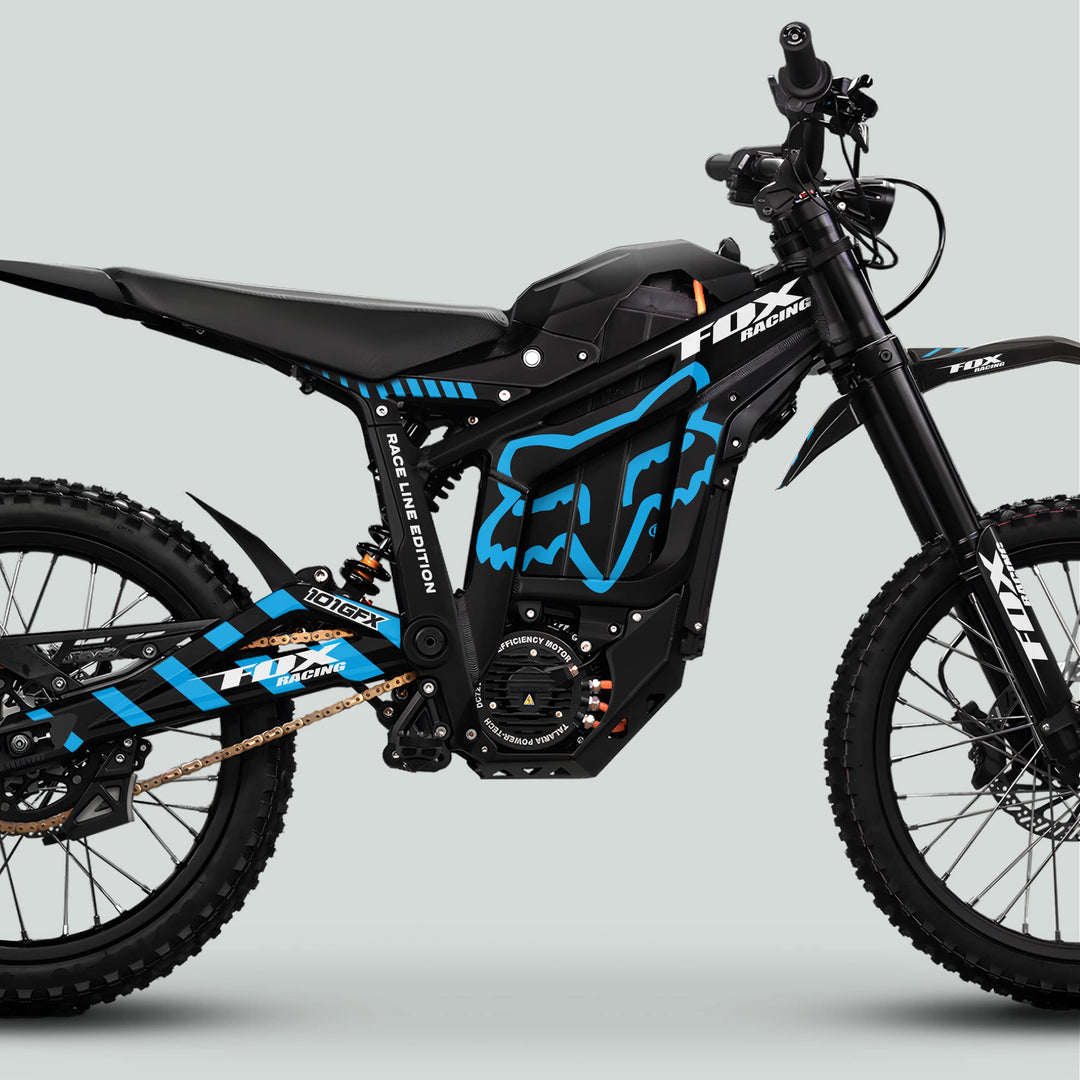 Side-view of Talaria Sting MX5 PRO Graphics Kit FOX RACELINE, showcasing black with blue accents, long-travel forks, coil suspension, knobby tires, and lightweight frame.