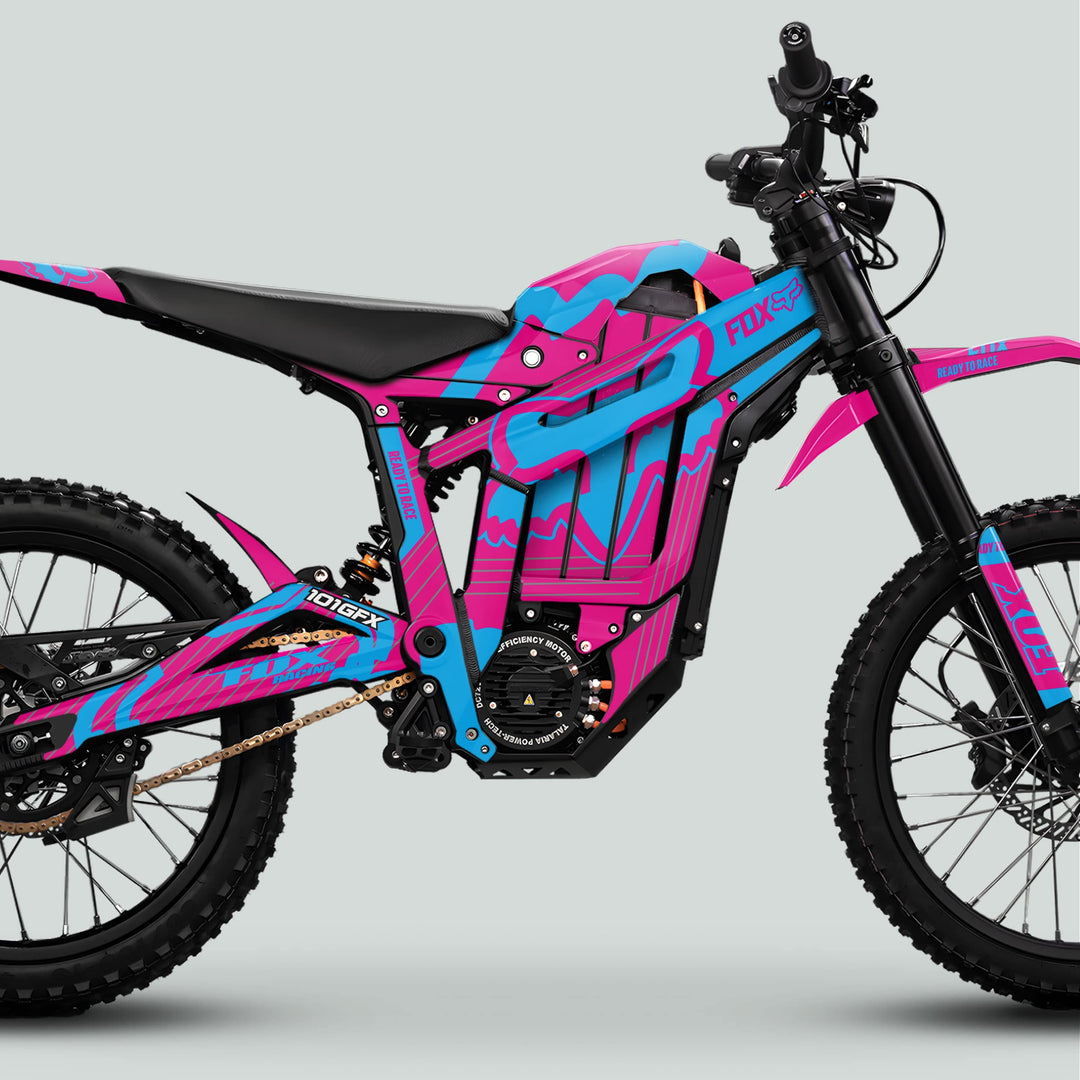 Talaria Sting MX5 PRO Graphics Kit: Side-view of electric dirt bike with FOX STRIPES Magenta Cyan Decals, showcasing knobby tires, chain drive, and suspension.