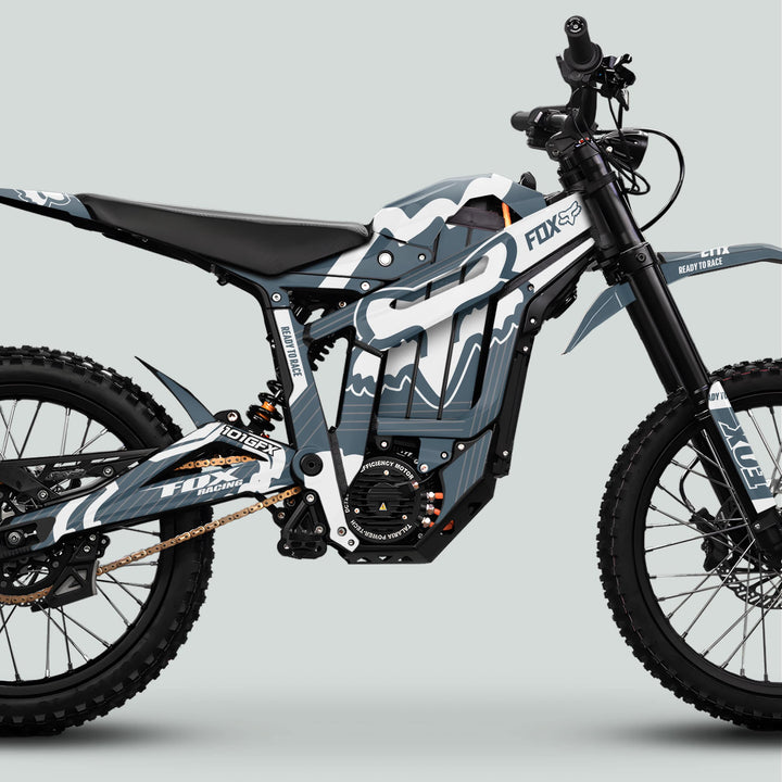 Side-profile of a Talaria Sting MX5 PRO with FOX STRIPES Grey White Decals, featuring a tubular frame, large battery, suspension, knobby tires, and striking graphics.