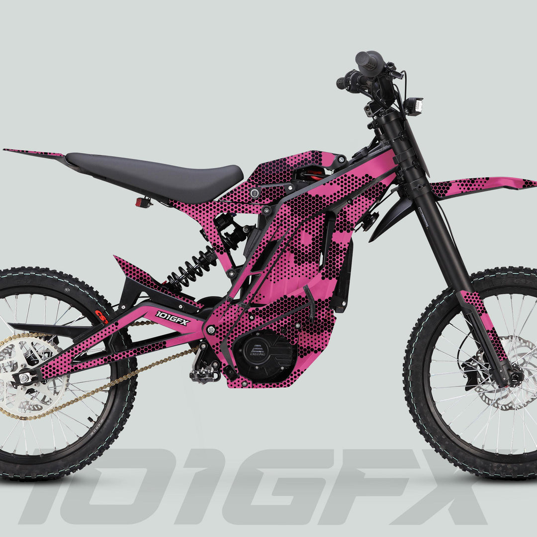 Side-profile of a battery-powered off-road motorcycle featuring the E Ride Pro SS Graphics Kit HEXOCAM PINK with a distinctive pink and black honeycomb wrap.