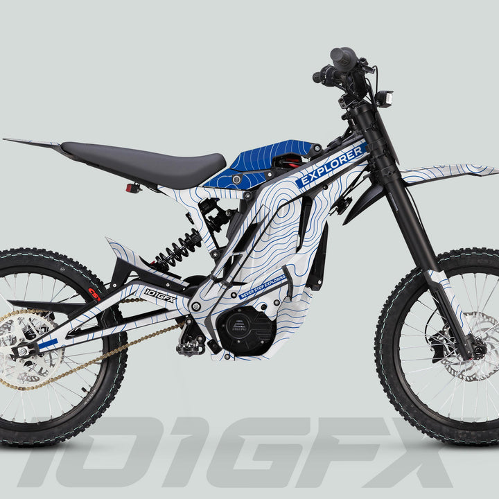 Side-view of an electric off-road bike with E Ride Pro SS Graphics Kit EXPLORER White Blue, featuring a lightweight frame, electric motor, and robust suspension.