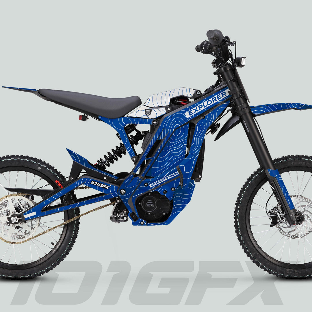 Side-profile of an E Ride Pro SS Graphics Kit EXPLORER Blue White on an electric dirt-bike, showcasing blue topographic graphics, knobby tires, and mid-mounted motor.