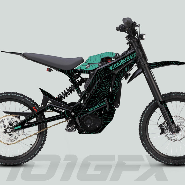 Side-profile of the E Ride Pro SS Graphics Kit EXPLORER Black Mint on an e-dirt bike, showcasing its high-clearance frame, telescopic forks, and knobby tires.