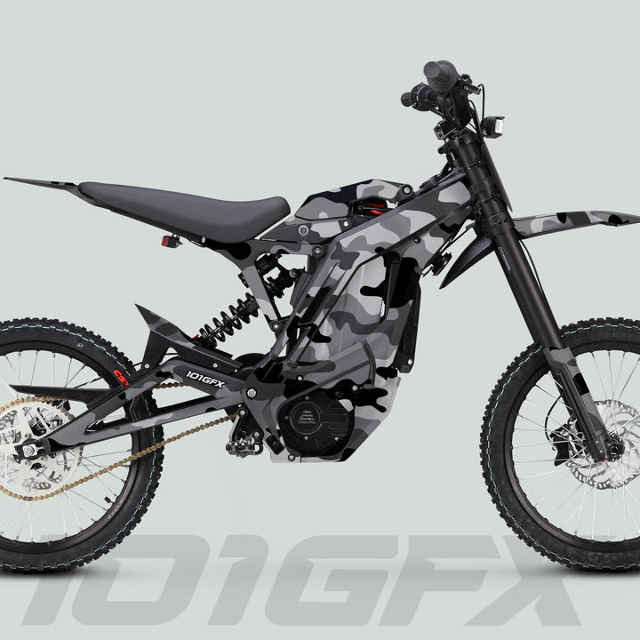 E Ride Pro SS Graphics Kit CAMOUFLAGE SNOW on an electric dirt bike, showcasing its camouflage wrap, full suspension, knobby tires, and visible battery and motor.