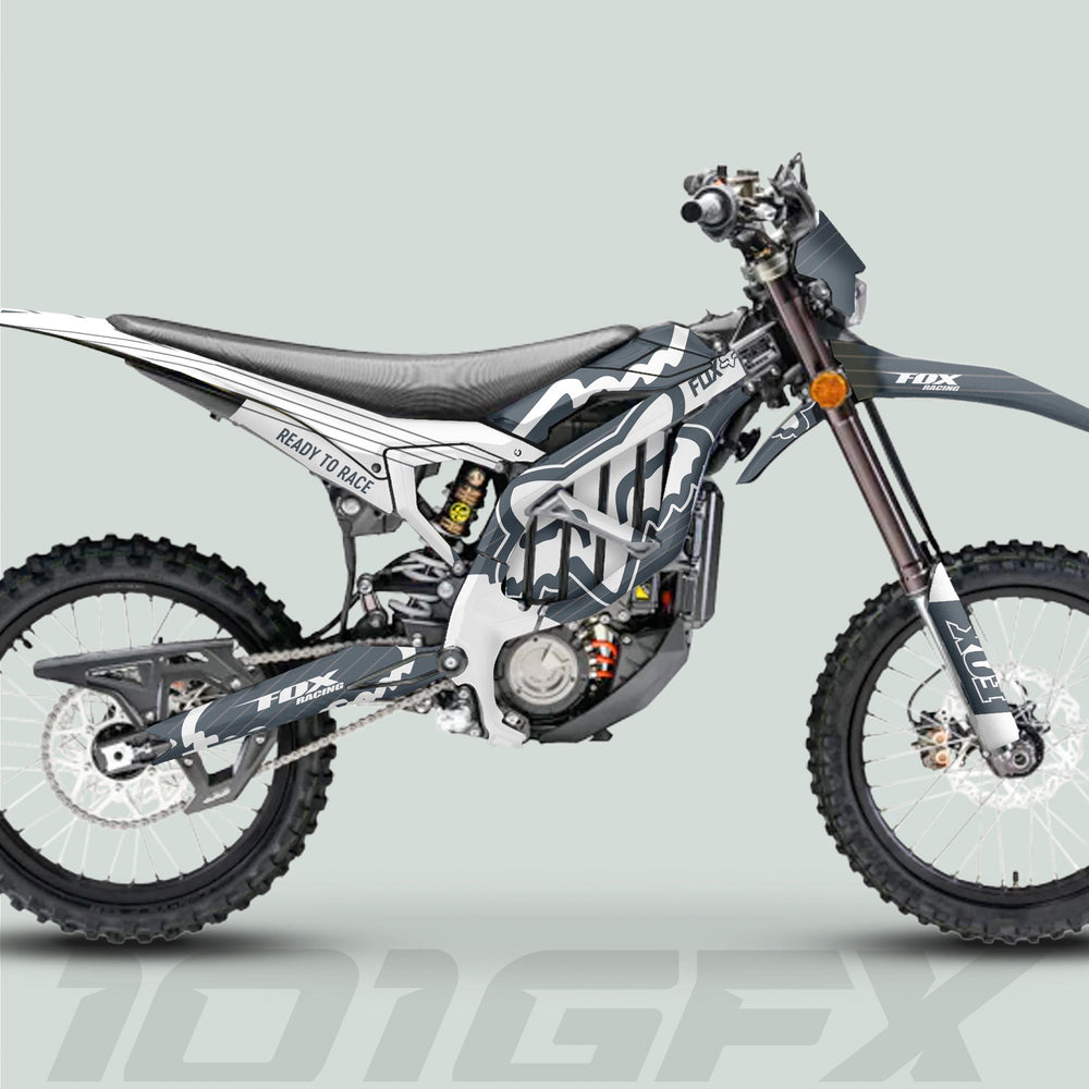 Side-view of a motocross bike with Surron Ultra Bee Graphics Kit FOX STRIPES Grey White, featuring vibrant Fox Racing decals on fork guards and swingarm.