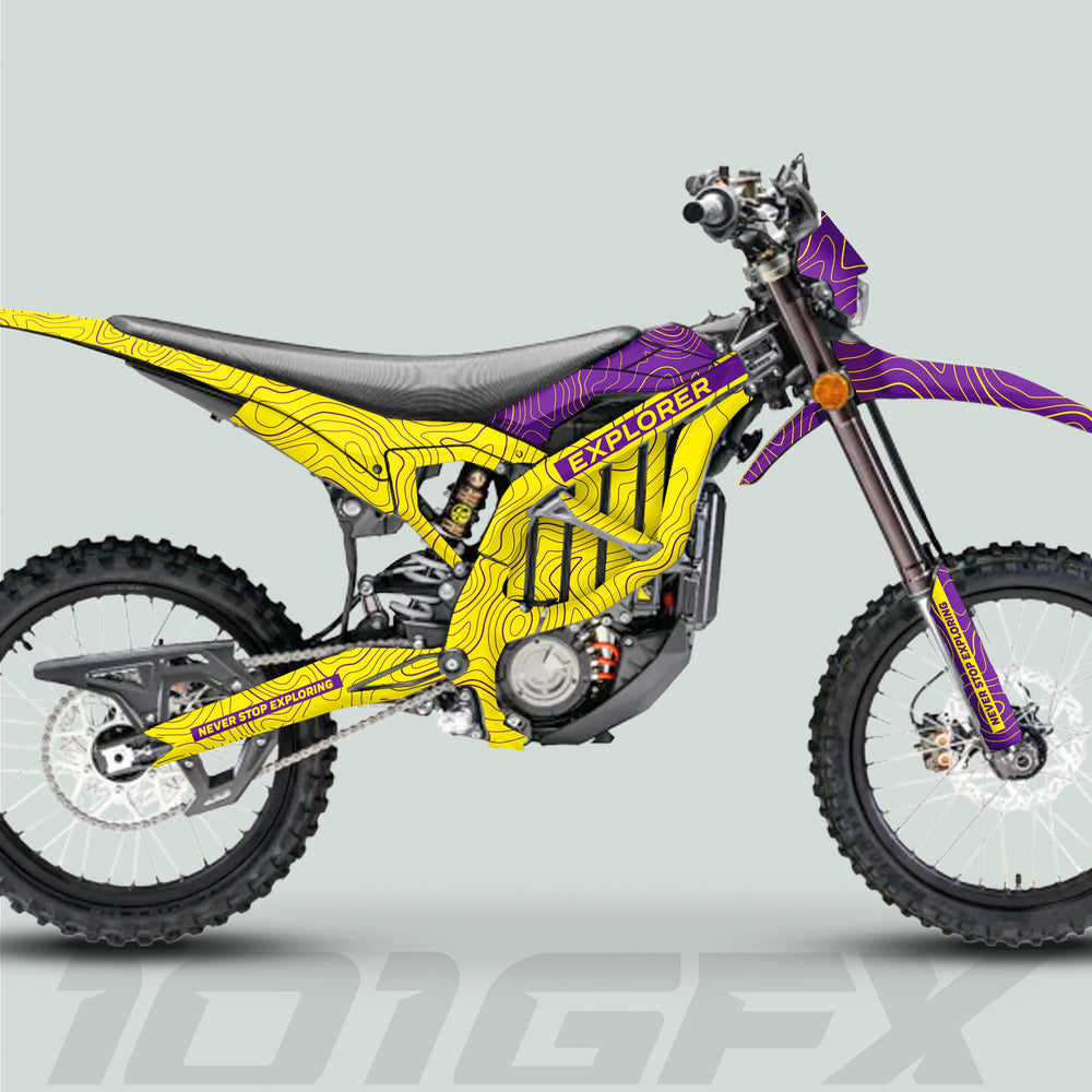 Surron Ultra Bee Graphics Kit EXPLORER YELLOW PURPLE on dirt bike; high-contrast topographic lines, “NEVER STOP EXPLORING” slogan, knobby tires, modern trail-ready design.