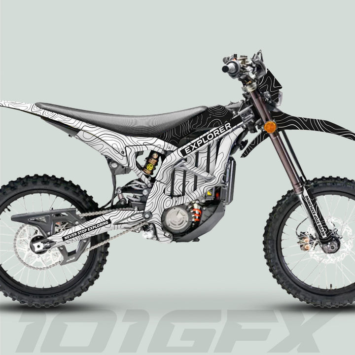 Surron Ultra Bee Graphics Kit EXPLORER WHITE BLACK on a dirt motorcycle, showcasing a topographic map design with “NEVER STOP EXPLORING” tagline, enhancing aesthetics and protection.