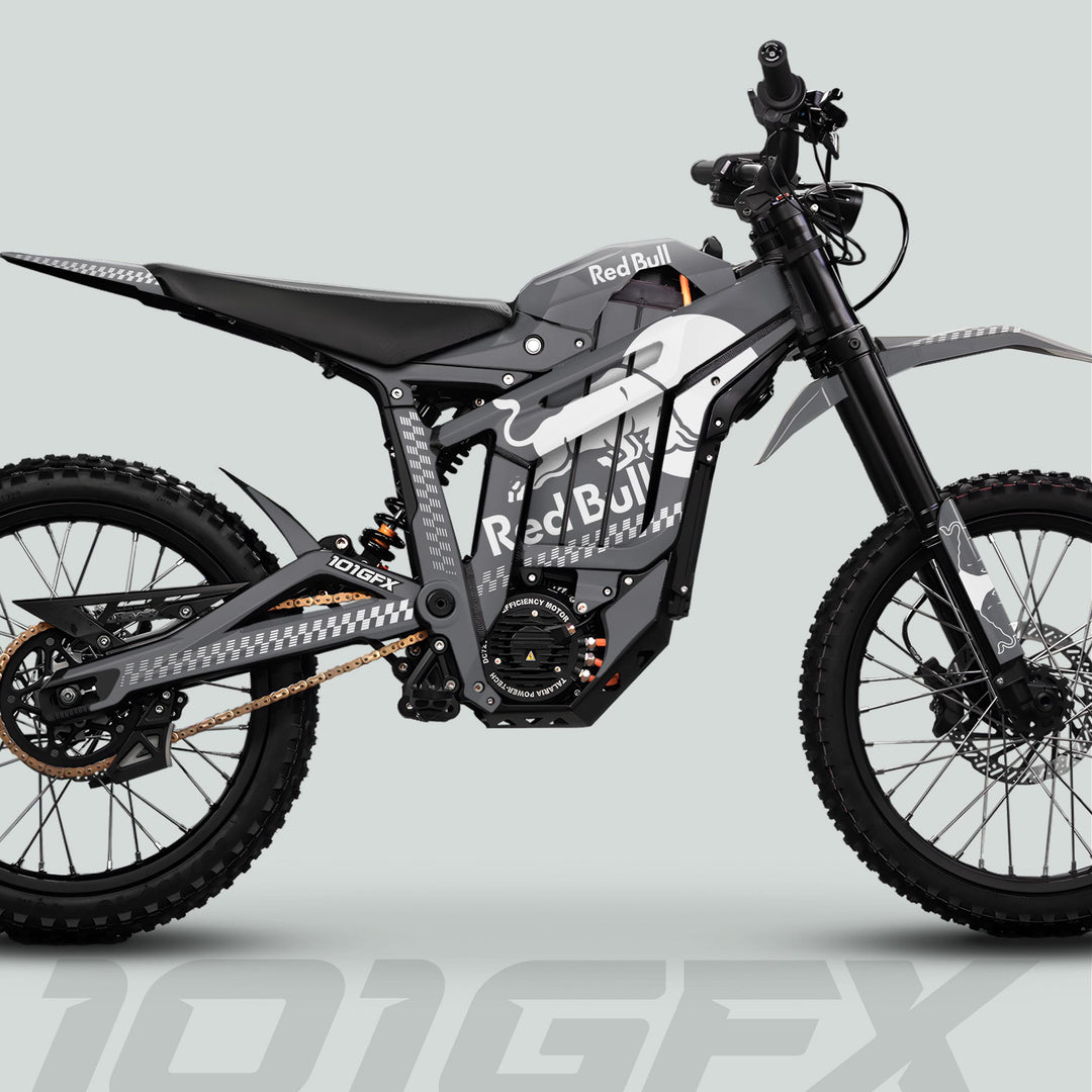 Side profile of a Red Bull-branded Talaria Sting MX5 PRO with REDBULL MONO Graphics Kit, showcasing dual-suspension, knobby tires, and chain drive.