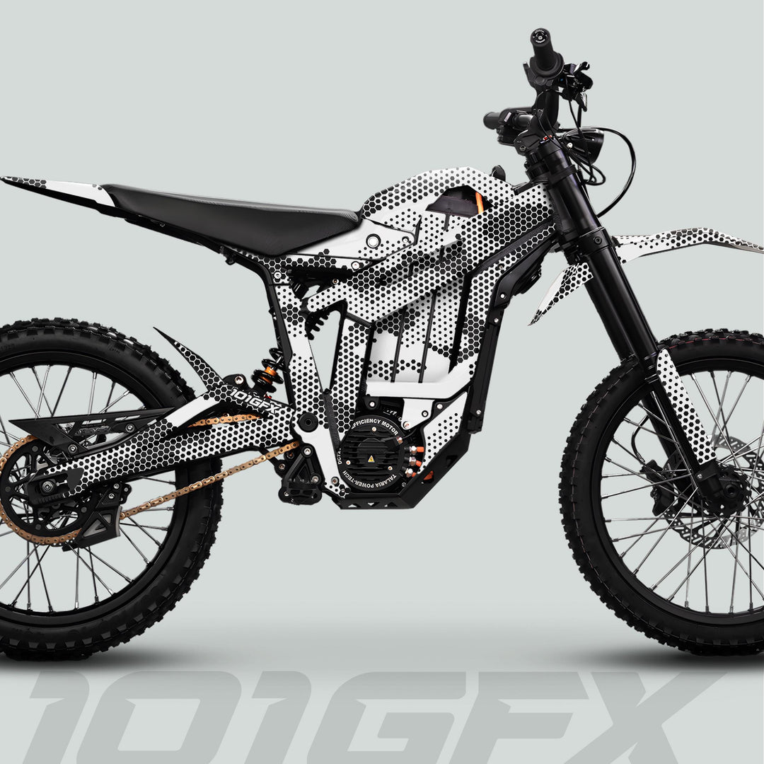 Side profile of an off-road electric dirt bike adorned with Talaria Sting MX5 PRO Graphics Kit HEXOCAM WHITE Decals, showcasing knobby tires and integrated battery pack.