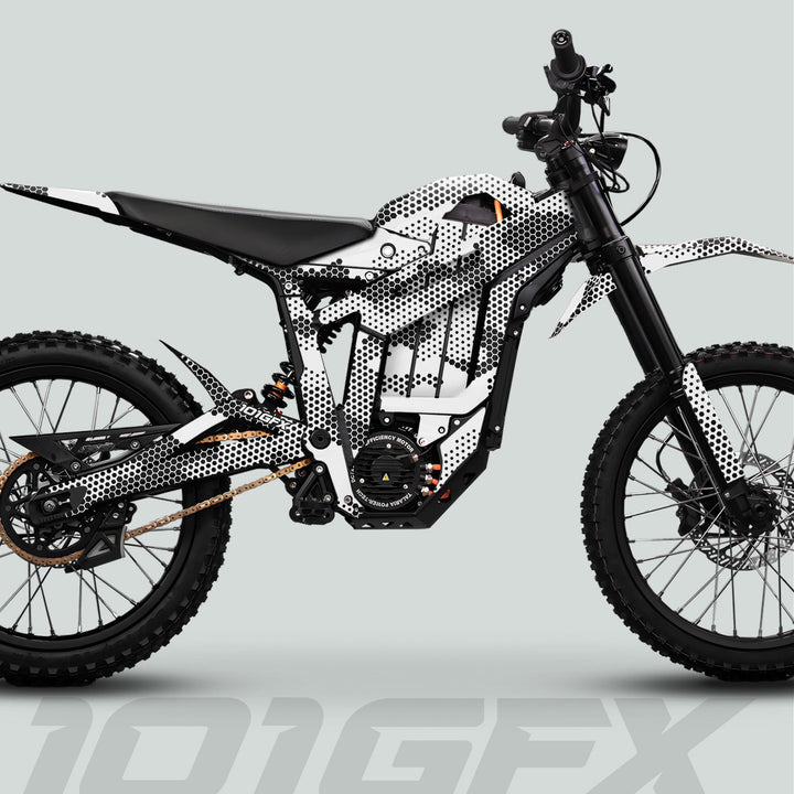 Side profile of an off-road electric dirt bike adorned with Talaria Sting MX5 PRO Graphics Kit HEXOCAM WHITE Decals, showcasing knobby tires and integrated battery pack.