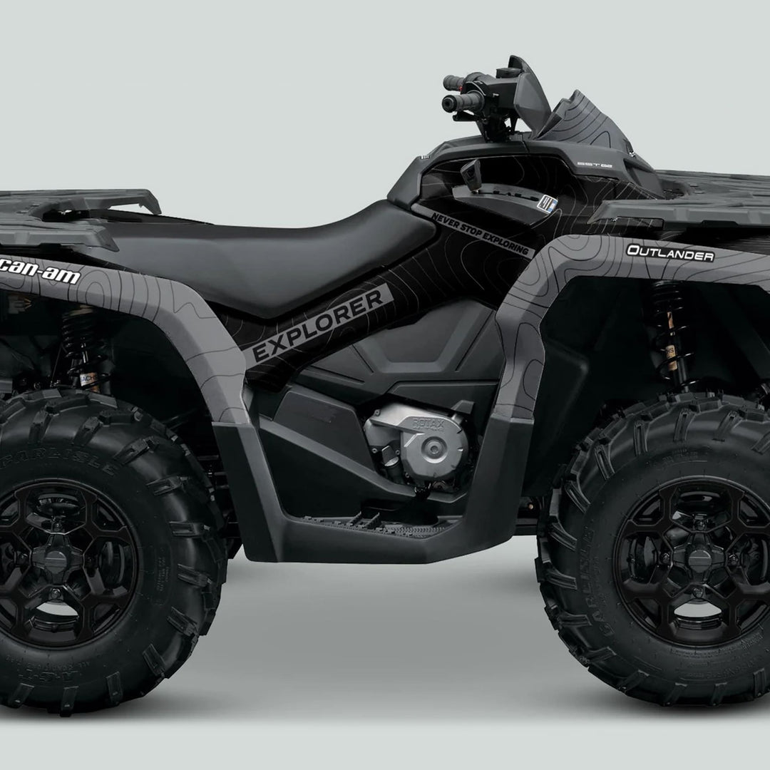 Can-Am OUTLANDER Graphics kit EXPLORER Black Grey on a rugged ATV, showcasing topographic-style graphics, handguards, and Never Stop Exploring motto on the panels.
