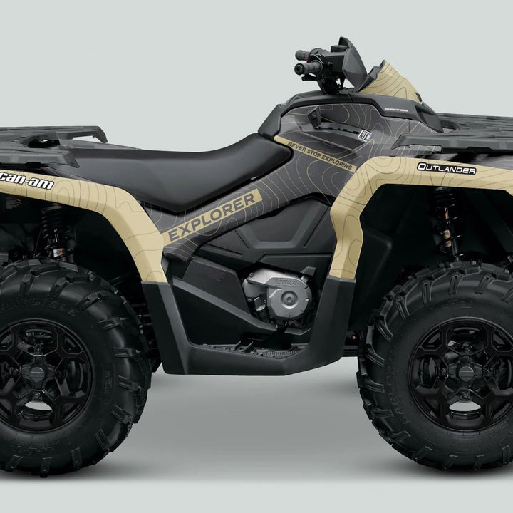Side view of a Can-Am OUTLANDER G2 Graphics Kit EXPLORER Grey Sand on an ATV, showcasing its rugged design, chunky tires, and protective graphics.