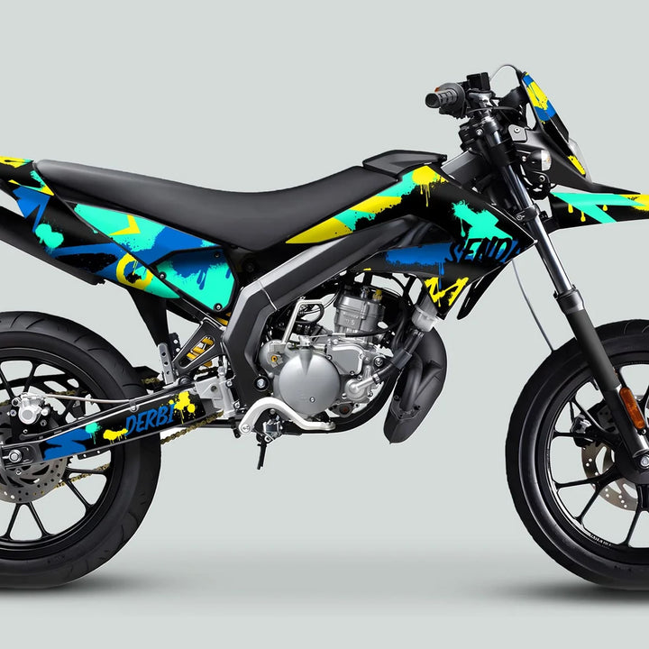 Derbi Senda Graphics Kit X-Treme 2011-2017 SPLASH BLUE MINT on motorcycle, featuring graffiti-style teal, blue, and yellow design. Enhances bike aesthetics with durable, easy-to-apply decals.