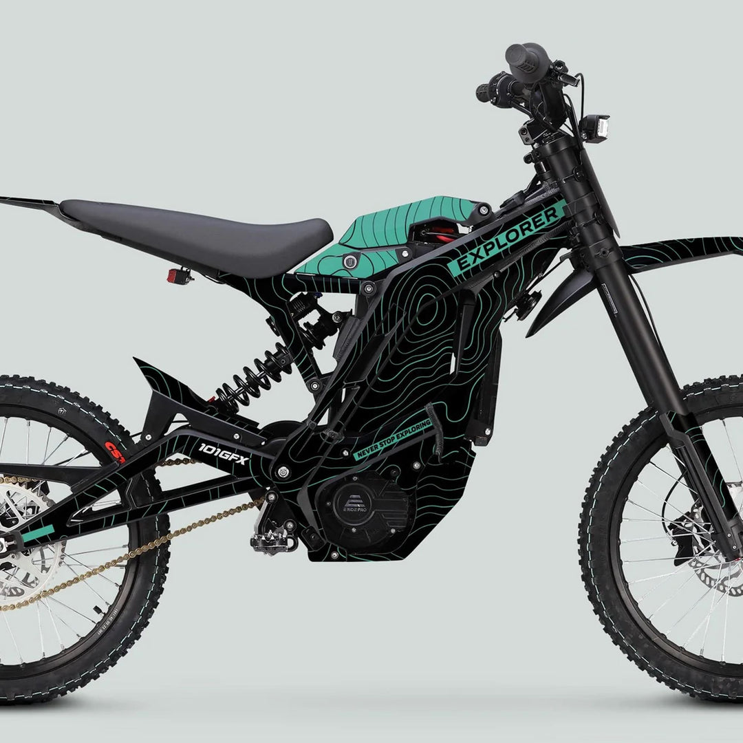 Electric off-road motorcycle with E Ride Pro SS Graphics Kit EXPLORER Black Mint, featuring knobbly tires, long-travel suspension, and teal topographic-map pattern on black frame.