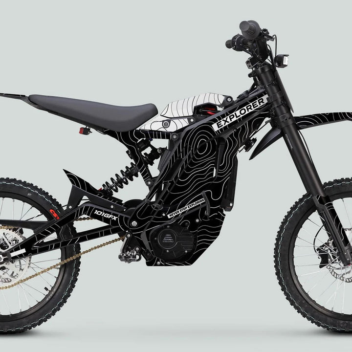 E Ride Pro SS Graphics Kit EXPLORER on a black and white electric dirt-bike, featuring knobby tires, suspension, and striking EXPLORER frame graphics.