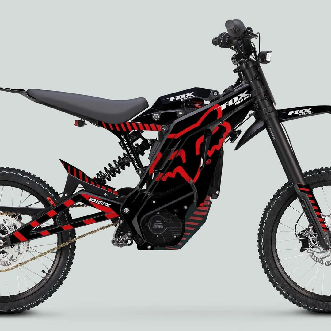 Side profile of a Fox Racing black-and-red e-dirt bike with E Ride Pro SS Graphics Kit, featuring full suspension, knobby tires, and a sporty, slim seat.