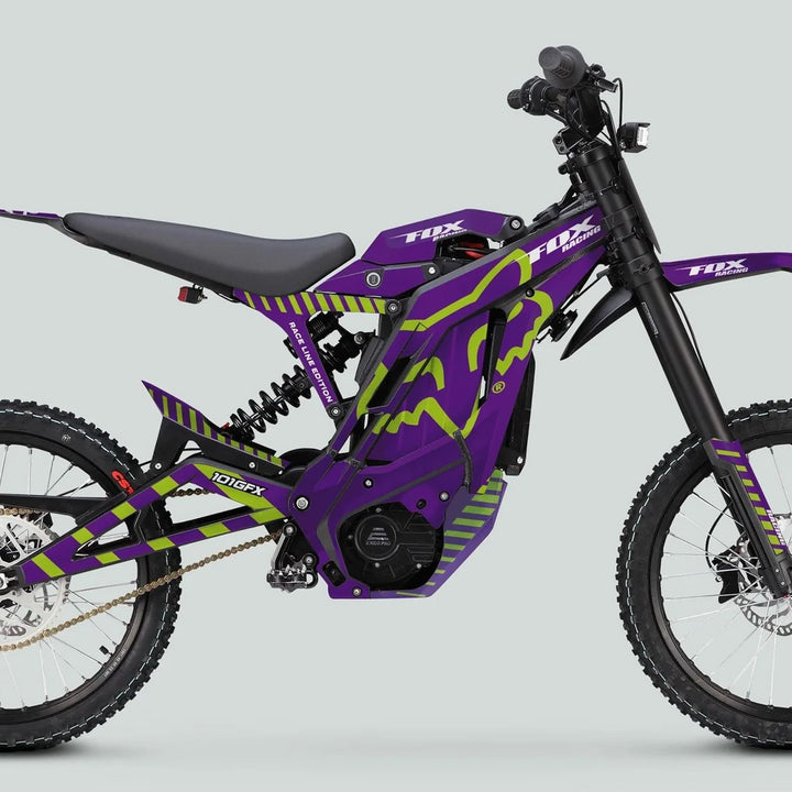 E Ride Pro SS Graphics Kit FOX Race Line Purple Green on electric dirt bike, showcasing vibrant decals, long-travel suspension, knobby tires, and chain drive for enhanced style and performance.