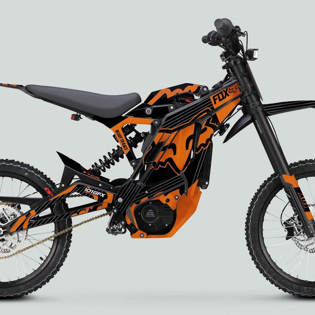 Side-profile of E Ride Pro SS Graphics Kit with FOX R stripes on an orange-and-black electric dirt bike, featuring knobby tires and E-Ride Pro motor housing.
