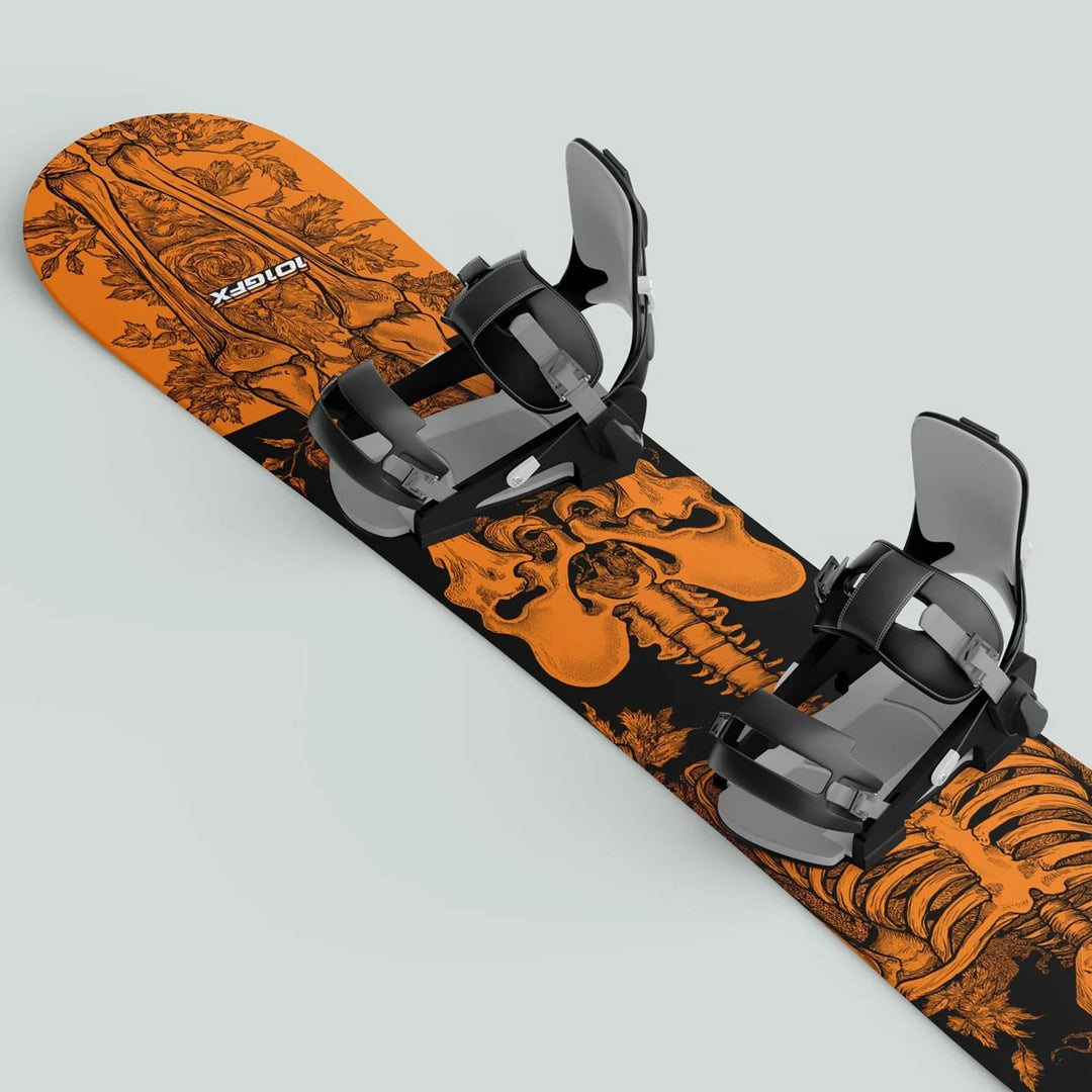 Snowboard with Snowboard Wrap RIDER FOREVER ORANGE, featuring skeleton and floral graphics, mounted with black-and-gray bindings, showcasing style and protection.