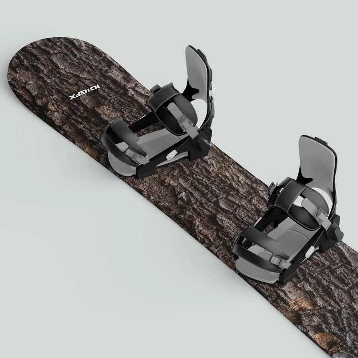 Snowboard Wrap WOOD PINE Snowboard sticker skin decals featuring a realistic tree-bark graphic with mounted black-and-gray bindings against a light-gray background.