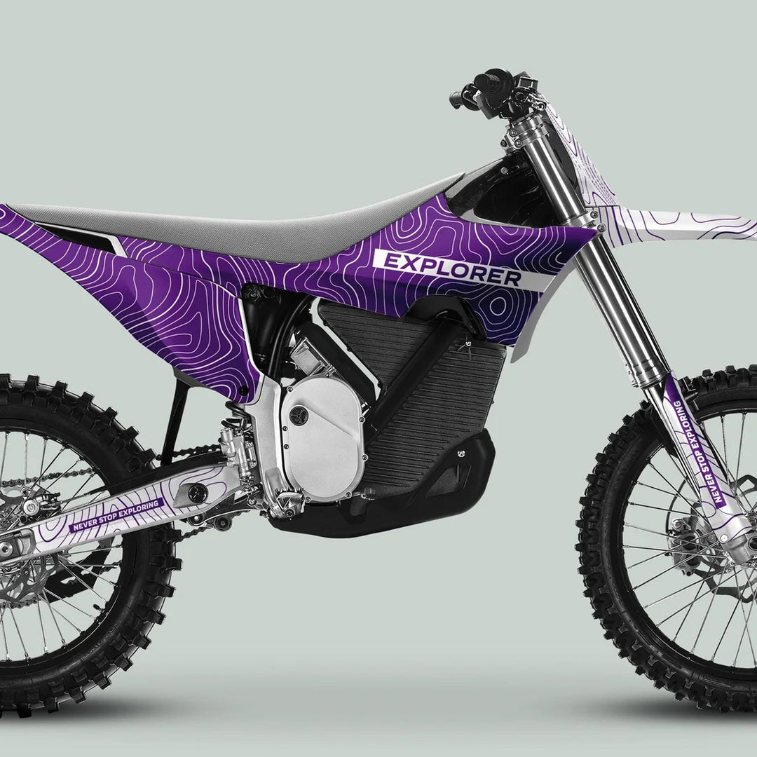 Stark Varg Graphics Kit EXPLORER PURPLE WHITE Decals on an electric off-road motorcycle, showcasing topographic design and NEVER STOP EXPLORING text, enhancing aesthetic and protection.