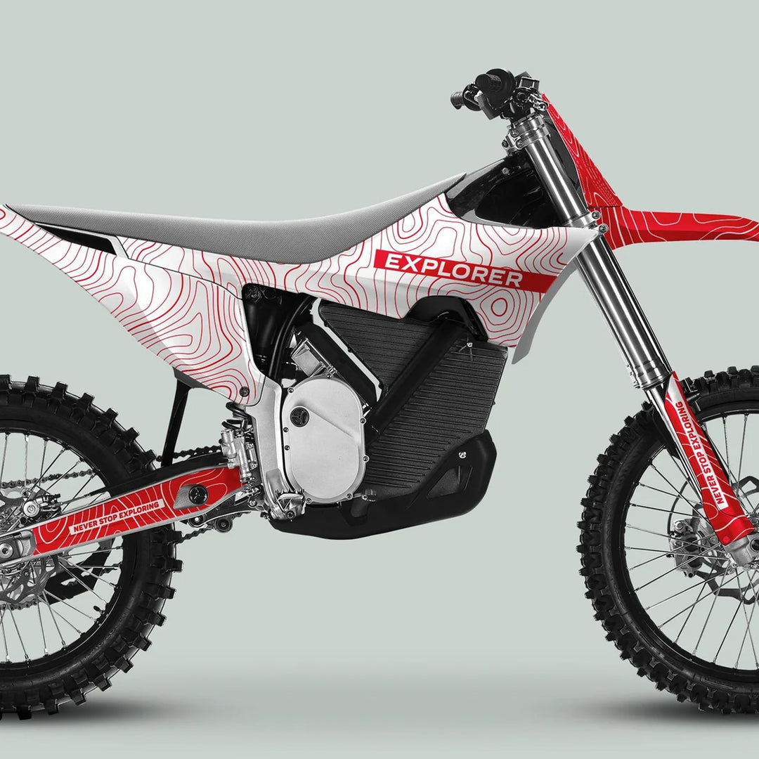 Side view of a dirt motorcycle with Stark Varg Graphics Kit EXPLORER WHITE RED Decals, featuring topographic design and text on swingarm and fork guards.