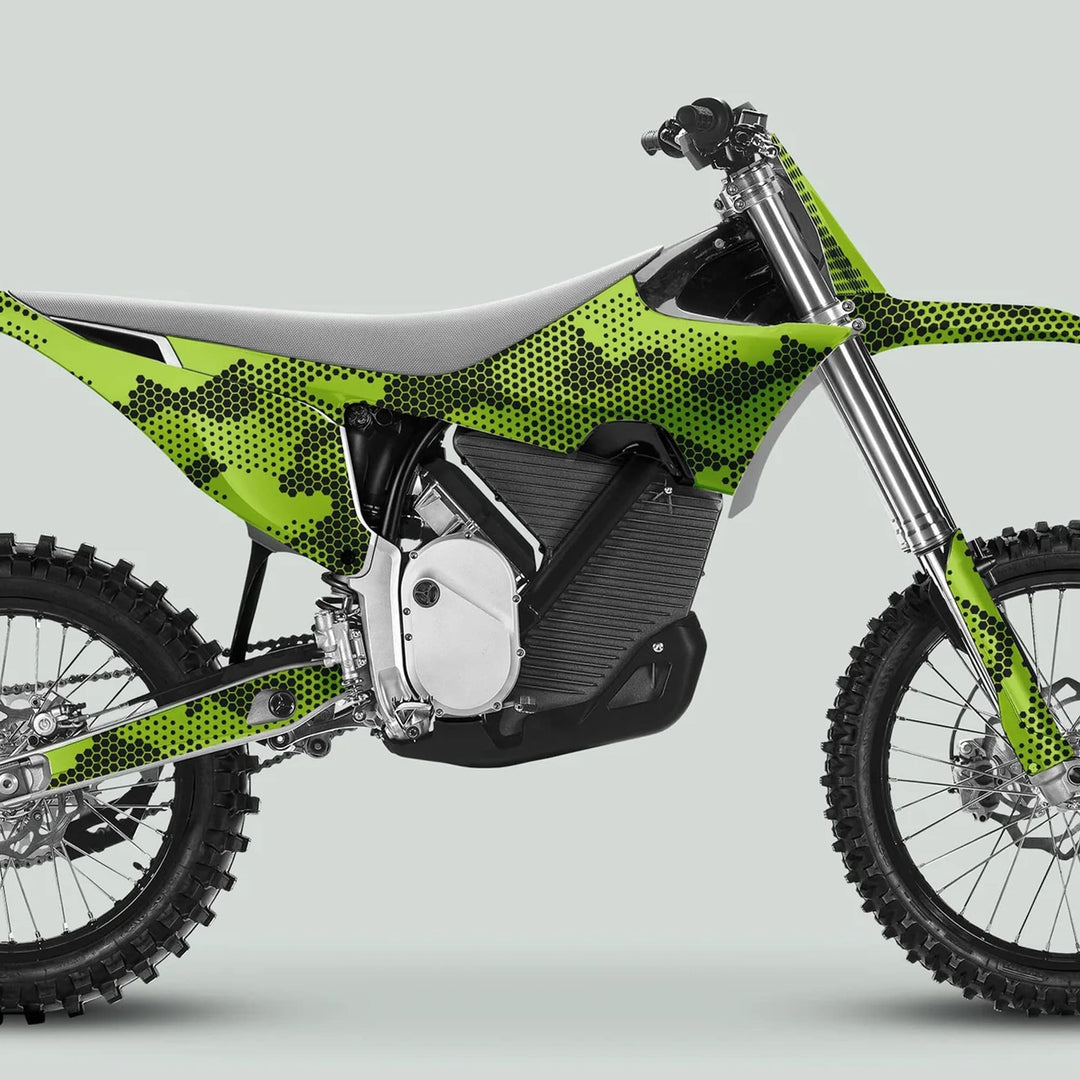 Side-profile of a dirt bike with Stark Varg Graphics Kit HEXOCAM GREEN decals, featuring electric motor, knobby tires, and aggressive green camo pattern.