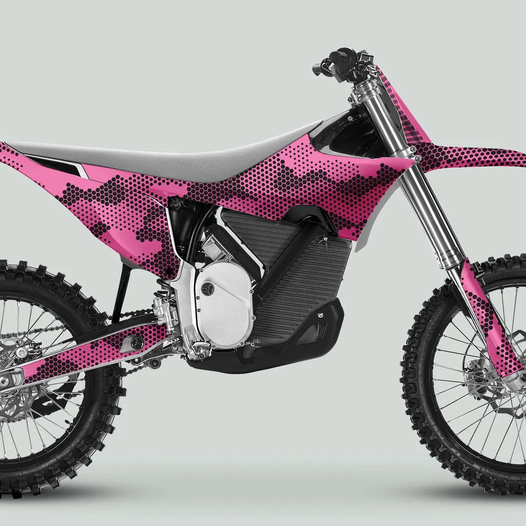 Side profile of a motocross bike with Stark Varg Graphics Kit HEXOCAM Pink Decals, featuring a camo design, knobby tires, and engine details.