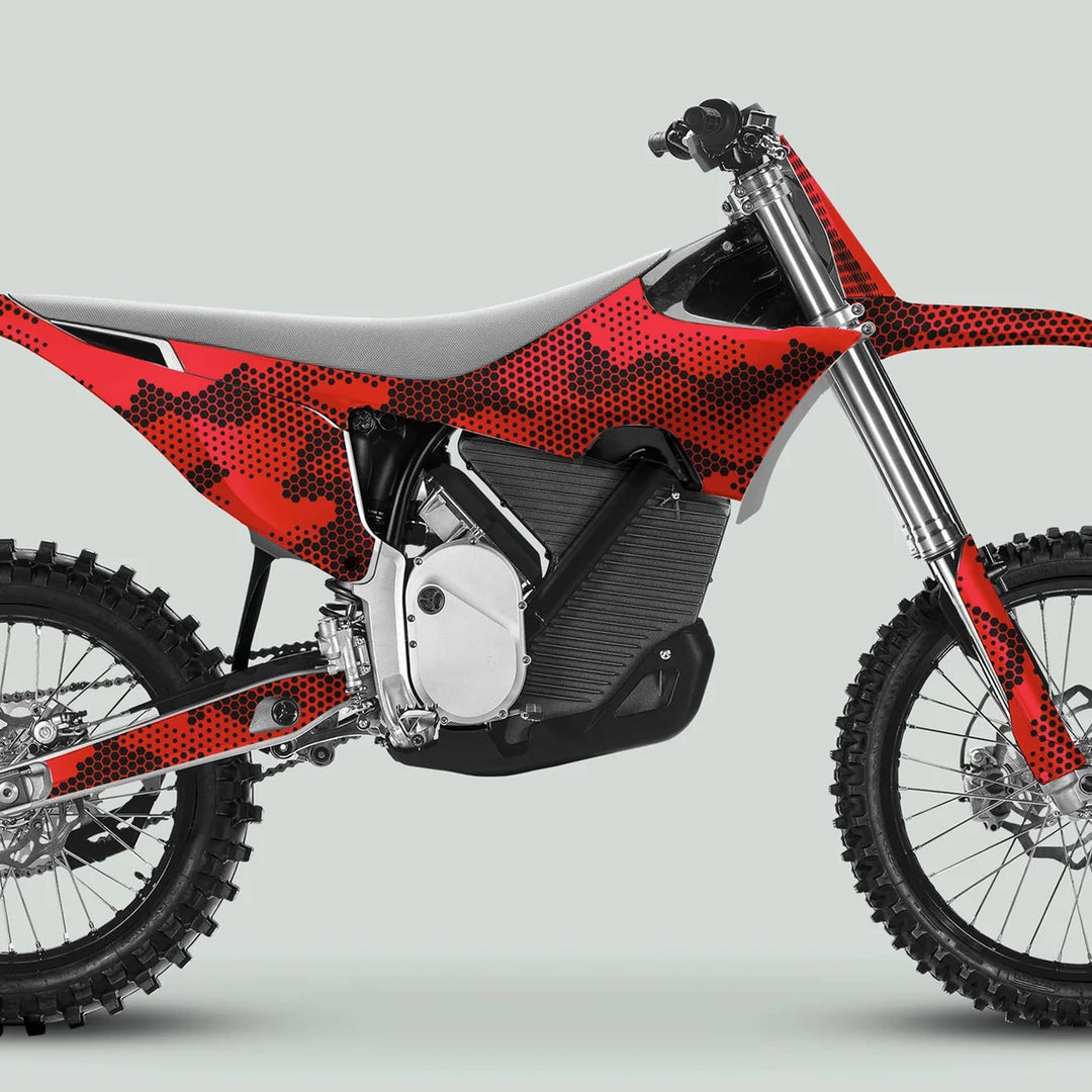 Side-view of a motocross bike featuring Stark Varg Graphics Kit HEXOCAM Red Decals, showcasing knobby tires, electric power-unit, and bold camouflage design.