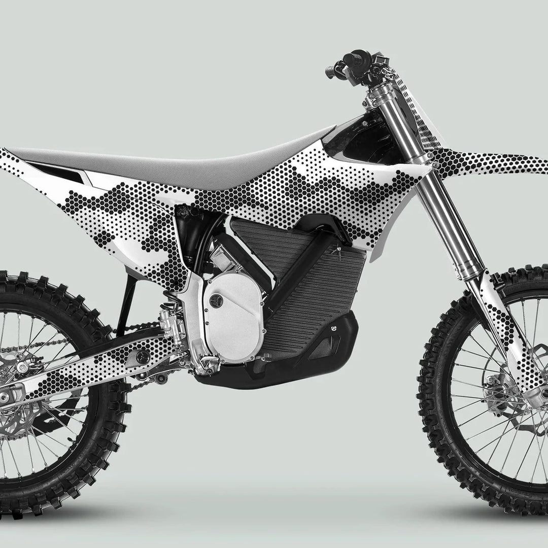 Side-view of a dirt bike featuring Stark Varg Graphics Kit HEXOCAM White Decals, showcasing a camo dot pattern on the electric power-unit area.
