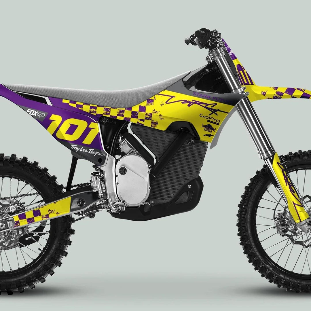 Stark Varg Graphics Kit RACE PURPLE Yellow Decals Stickers on electric motocross bike with knobby tires, showcasing Troy Lee–style livery and sponsor decals.