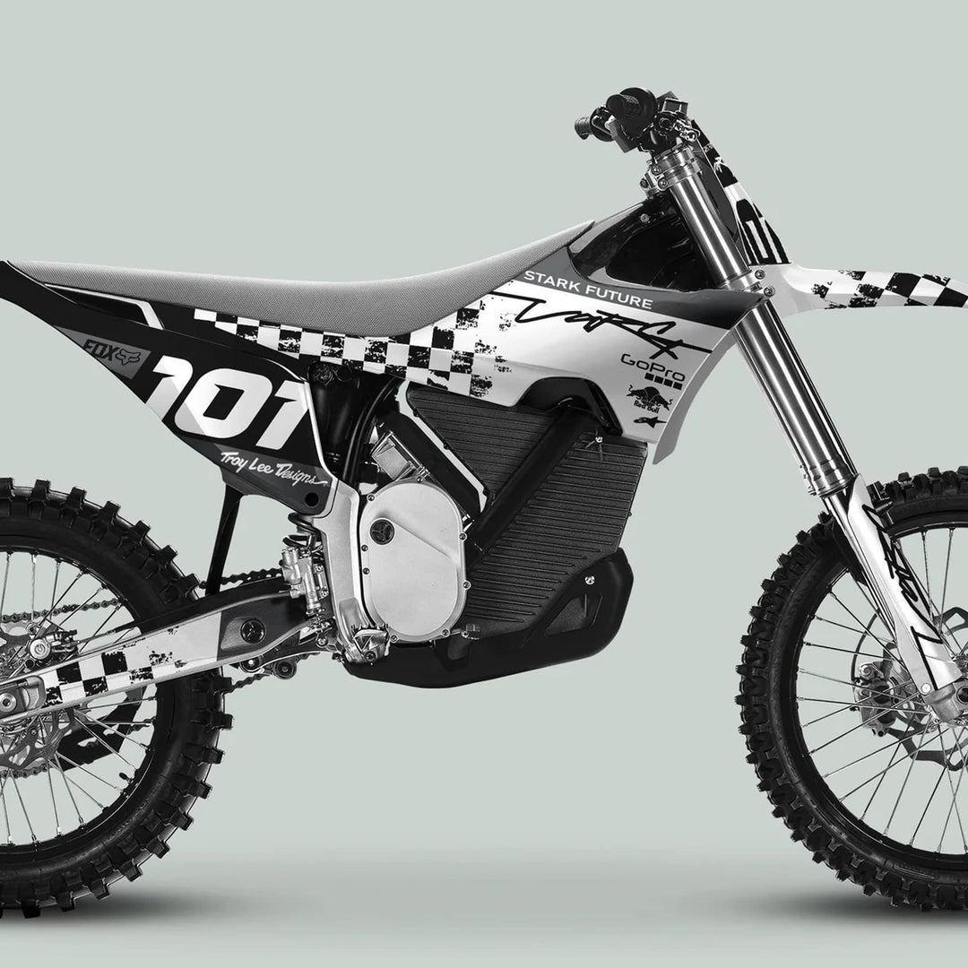 Side-profile of a dirt bike featuring Stark Varg Graphics Kit RACE BLACK White Decals Stickers, showcasing knobby tires, suspension, and sleek racing graphics with branding.