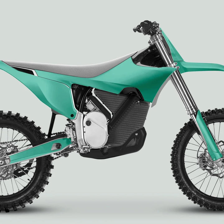 Side profile of an electric dirt motorcycle with Stark Varg Graphics Kit SOLID COLOR MINT Stickers, showcasing knobby tires, front suspension, and glossy decals.