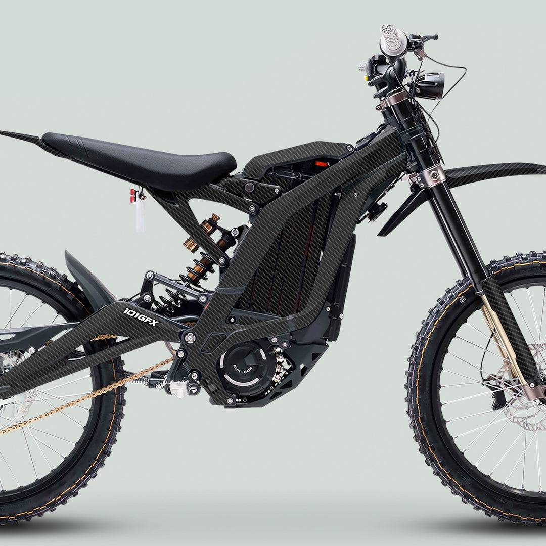 Surron Light Bee X Graphics Kit CARBON ORIGINAL on an e-dirt bike, showcasing carbon-style frame, knobbly tires, and exposed components for trail riding enhancement.