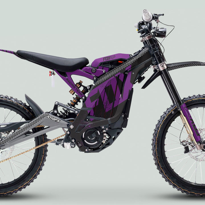 Surron Light Bee X Graphics Kit FOX DUST Black Purple on electric dirt-bike, showcasing black and purple design, knobby tires, and visible electric components against a pale grey background.