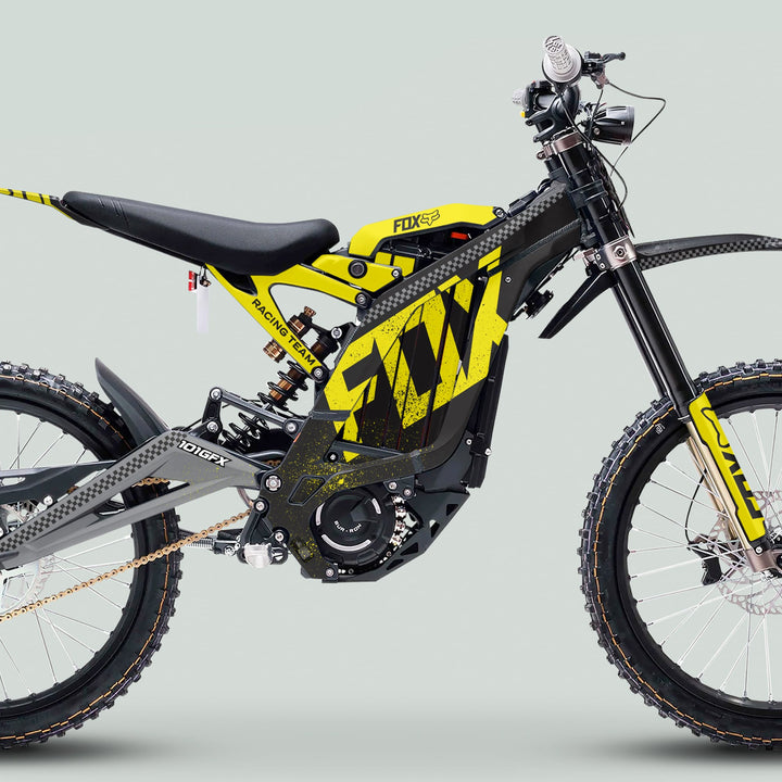 Side profile of an electric motocross e-bike with Surron Light Bee X Graphics Kit FOX DUST Black Yellow, showcasing its bold design and rugged features.
