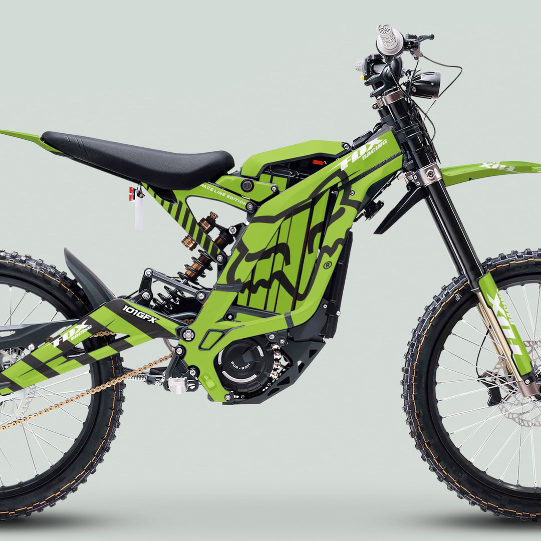 Surron Light Bee X Graphics Kit FOX RACE LINE Green Black on a motocross-style e-bike with knobby tires, telescopic forks, and branded frame panels.