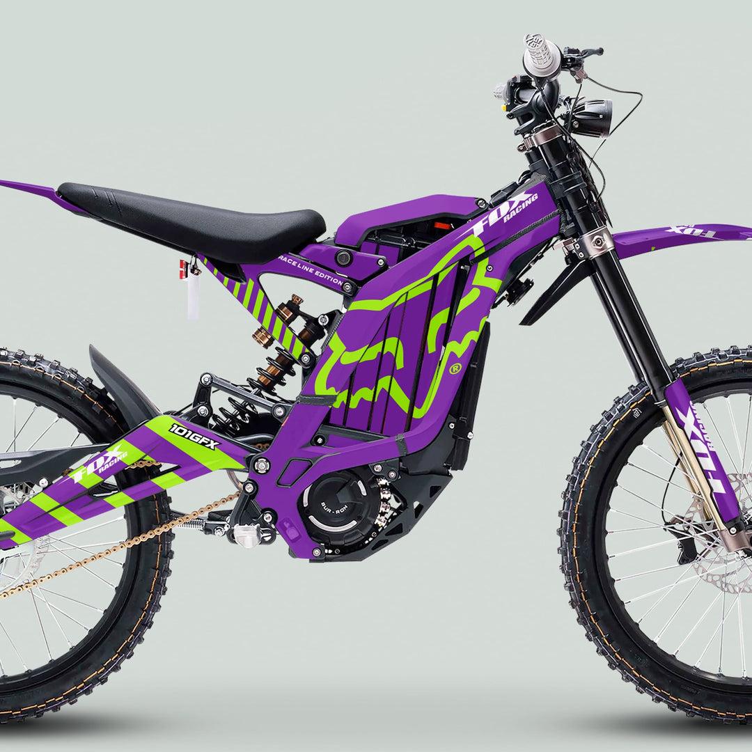 Surron Light Bee X Graphics Kit FOX RACE LINE Purple Green on full-suspension electric dirt bike with knobby tires, showcasing durable, glossy vinyl with easy application.
