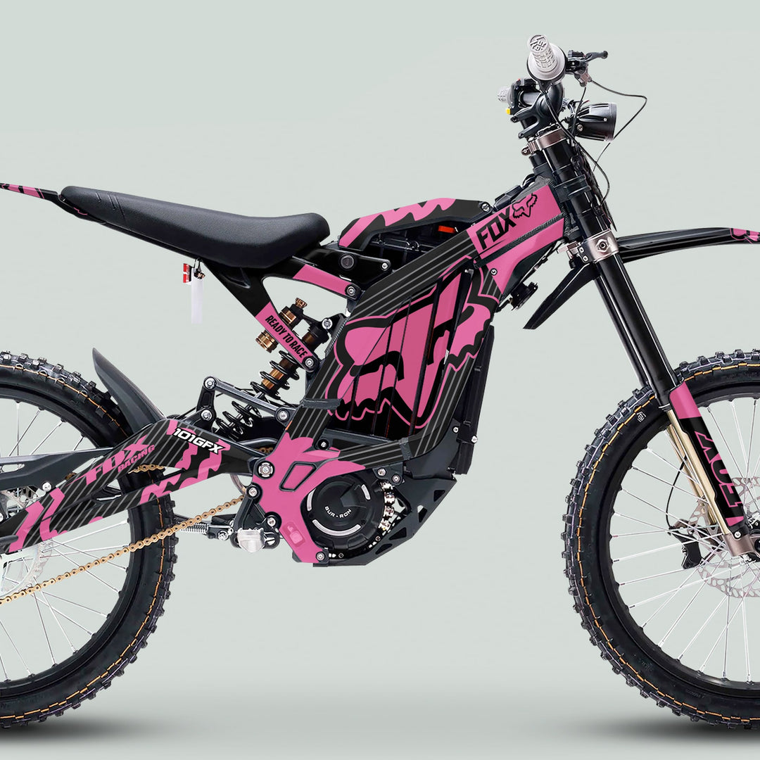 Side view of an electric off-road bike with the Surron Light Bee X Graphics Kit FOX STRIPES BLACK Pink, featuring rugged design and durable, eye-catching decals.