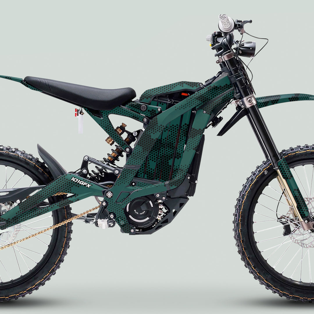 Surron Light Bee X Graphics Kit HEXOCAM AVENTUR on a green-and-black off-road electric motorcycle, showcasing knobby tires and visible electric motor.