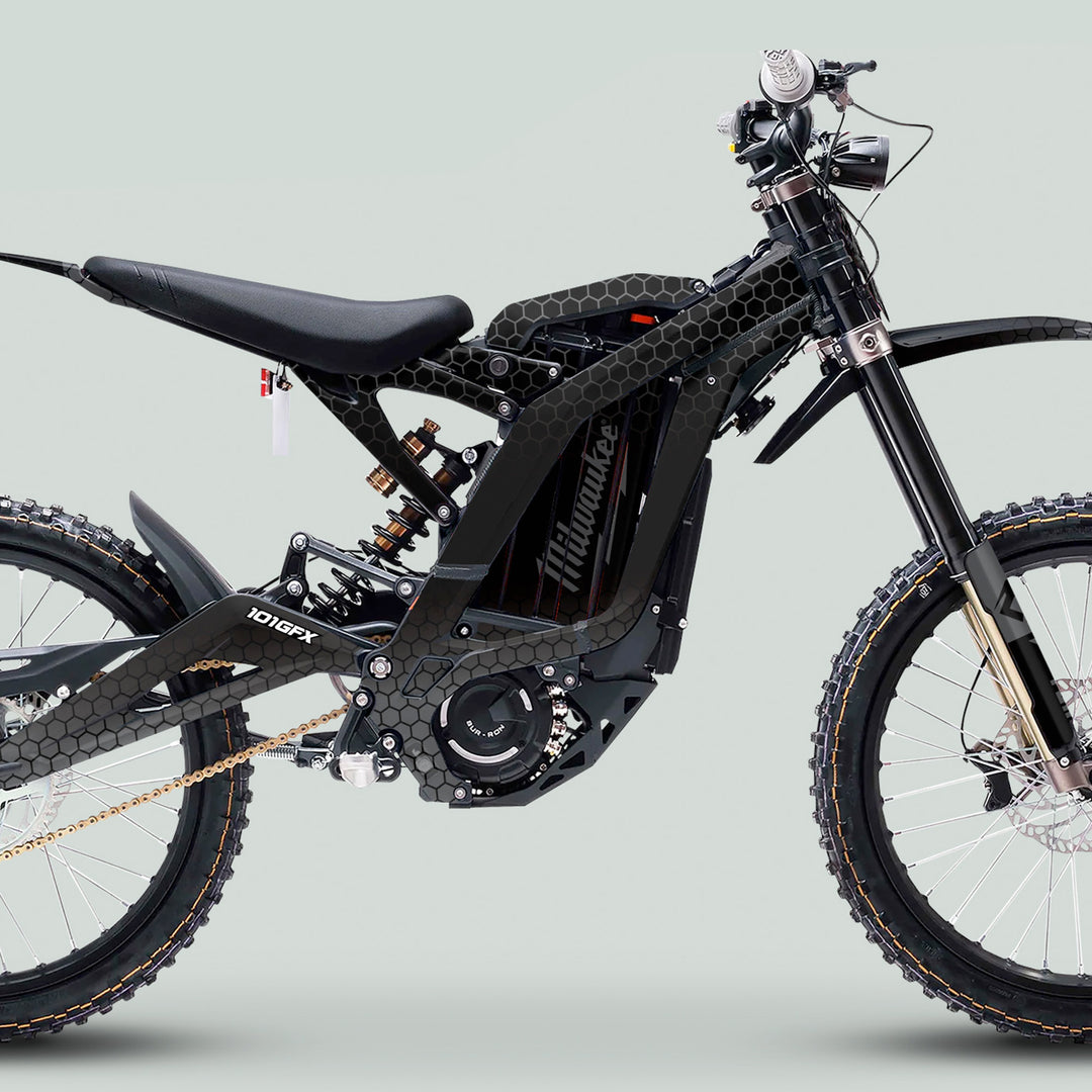 Surron Light Bee X Graphics Kit HONEYCOMB Black Grey on electric off-road bike with full-suspension, knobby tires, gold chain, and integrated battery-motor.