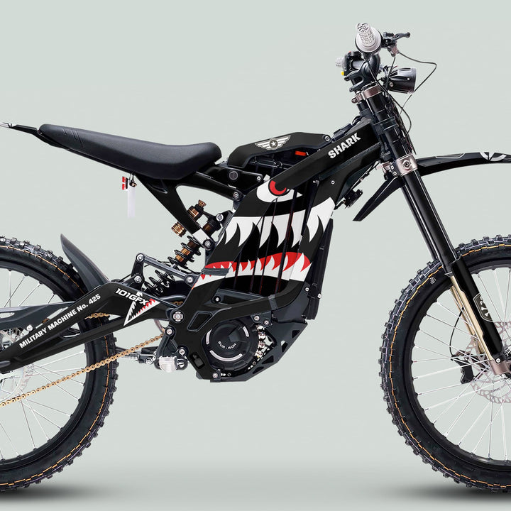 Surron Light Bee X Graphics Kit MILITARY SHARK Black: black e-bike with shark-mouth graphic, central motor, gold chain, full suspension, disc brakes, and rugged military design.