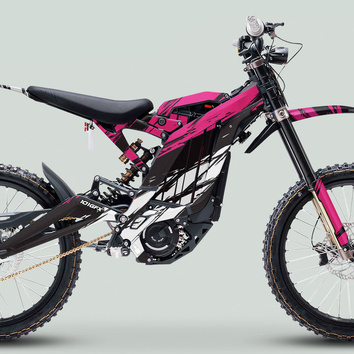 Side-view of electric dirt bike with Surron Light Bee X Graphics Kit SLICE BLACK Pink, featuring knobby tires, long-travel forks, and a vibrant pink-and-black frame.