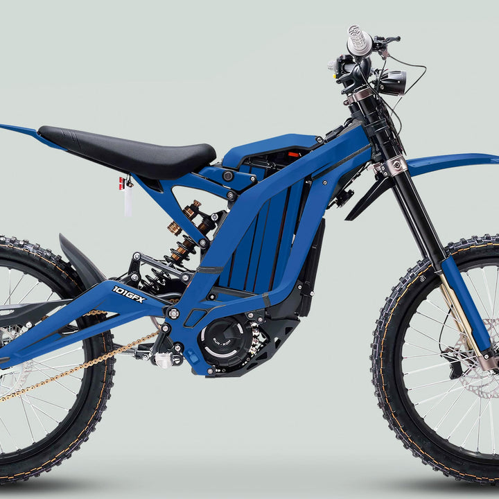 Side-view of a blue electric off-road bike featuring the Surron Light Bee X Graphics Kit MONO COLOR Blue, showcasing knobby tires, suspension, and motor housing.