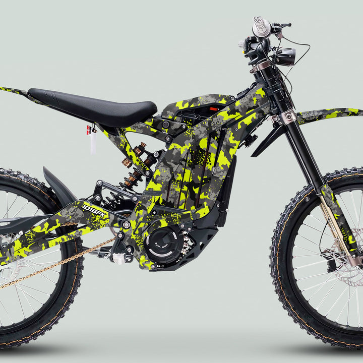 Surron Light Bee X Graphics Kit SPLAT CAMO Green on an electric dirt bike; features angular frame, knobby tires, and sleek camouflage pattern for enhanced style and protection.