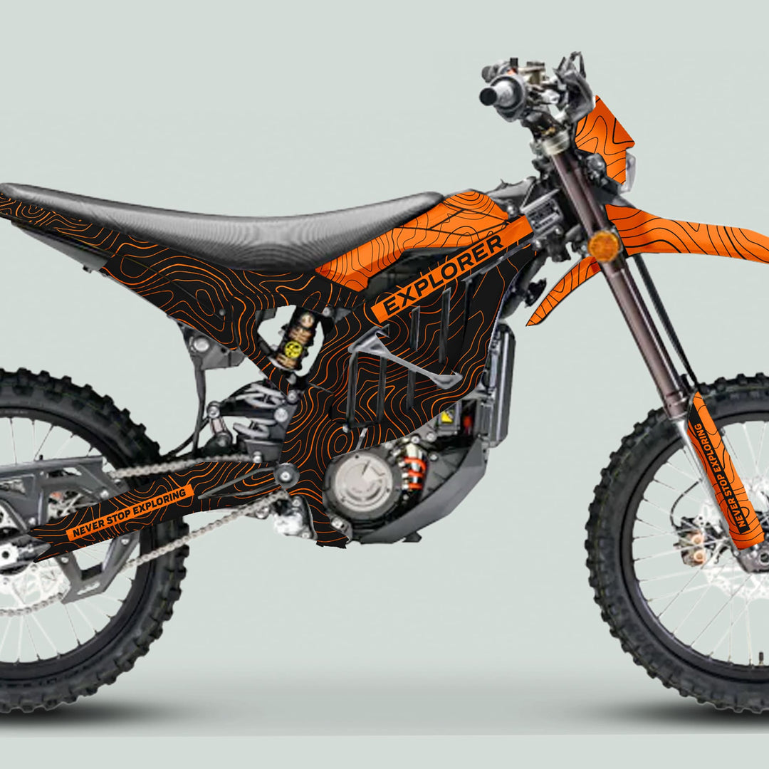 Surron Ultra Bee Graphics Kit EXPLORER BLACK ORANGE on a dirt bike, featuring a black-orange topographic design with EXPLORER and trail-ready components visible.