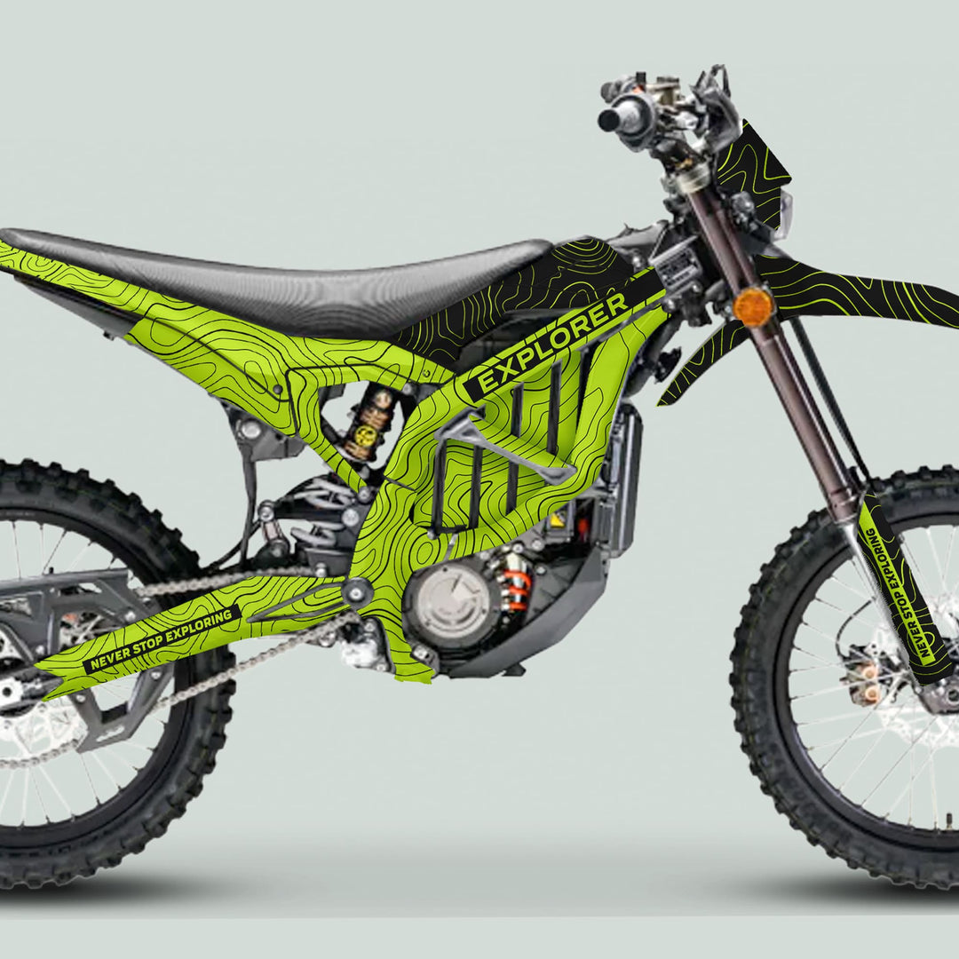 Surron Ultra Bee Graphics Kit EXPLORER GREEN BLACK on enduro bike, features topographic contour design, NEVER STOP EXPLORING slogan, knobby tires, electric motor.