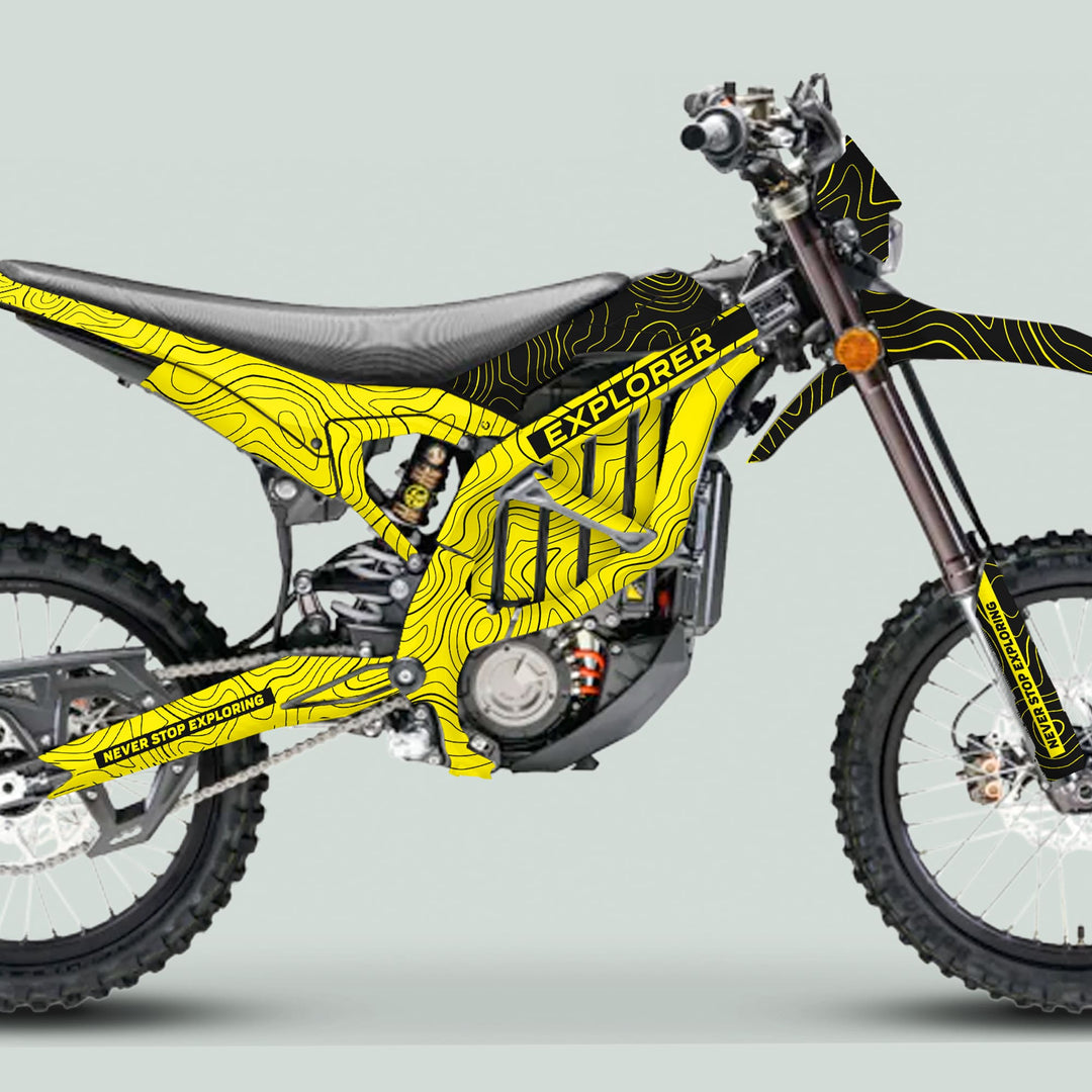 Side-profile of a dirt bike with a Surron Ultra Bee Graphics Kit EXPLORER YELLOW BLACK, featuring contour-map lines and “NEVER STOP EXPLORING” text.